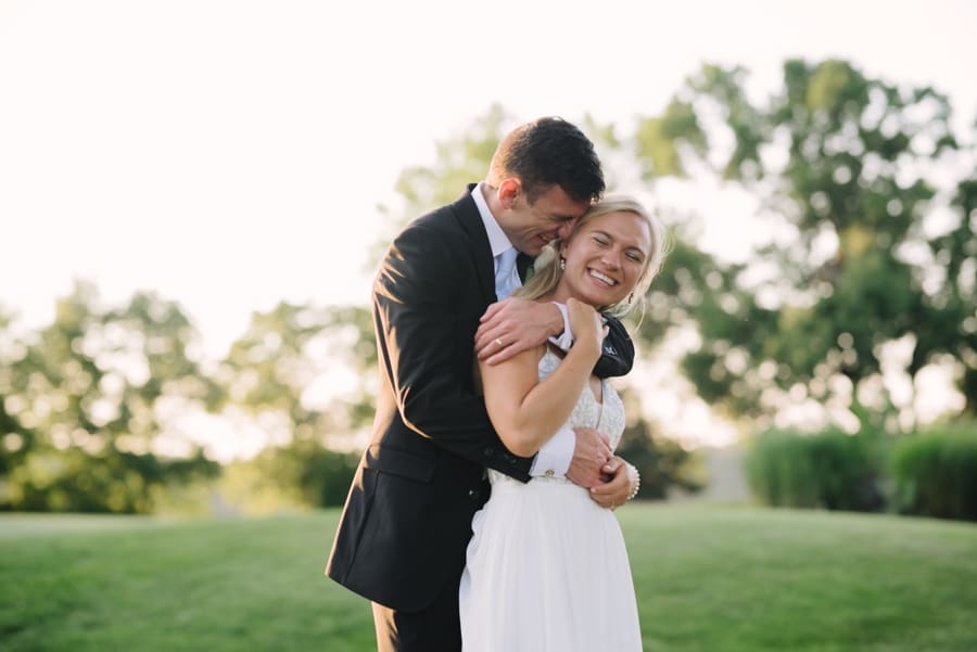 bride and groom hugging during sunset