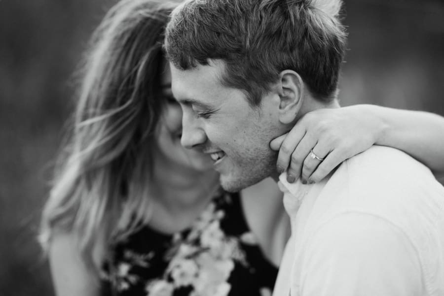 engaged couple embracing with ring visible
