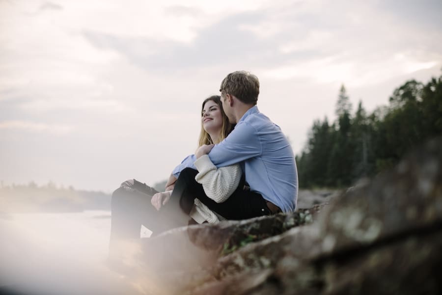 engaged couple at sunset beside lake superior