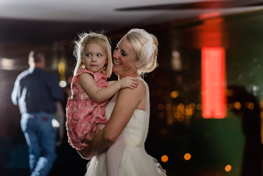 Bride dancing with flower girl during wedding reception