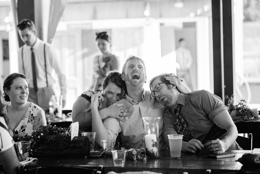 guests laughing at barn wedding reception