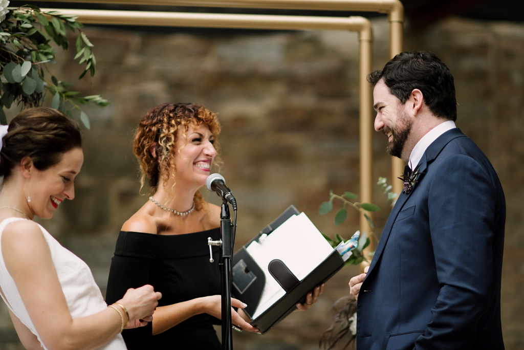 bride groom officiant laughing during wedding ceremony