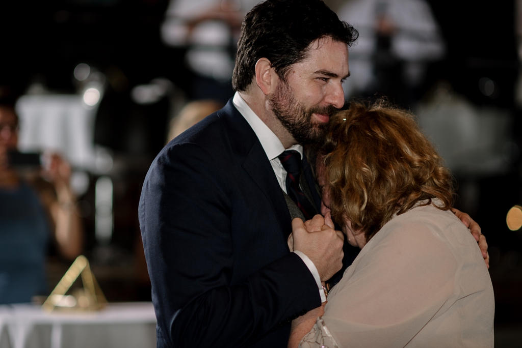 groom and emotional mom dancing at reception