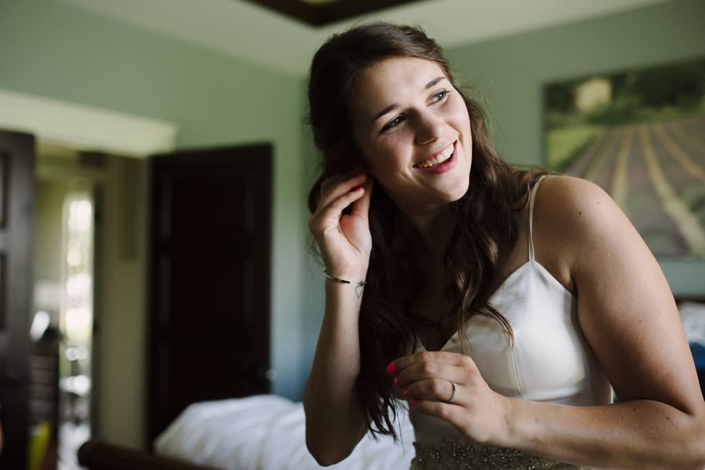 bride putting on earrings before wedding