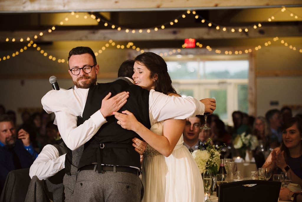 bride and groom hugging groomsman