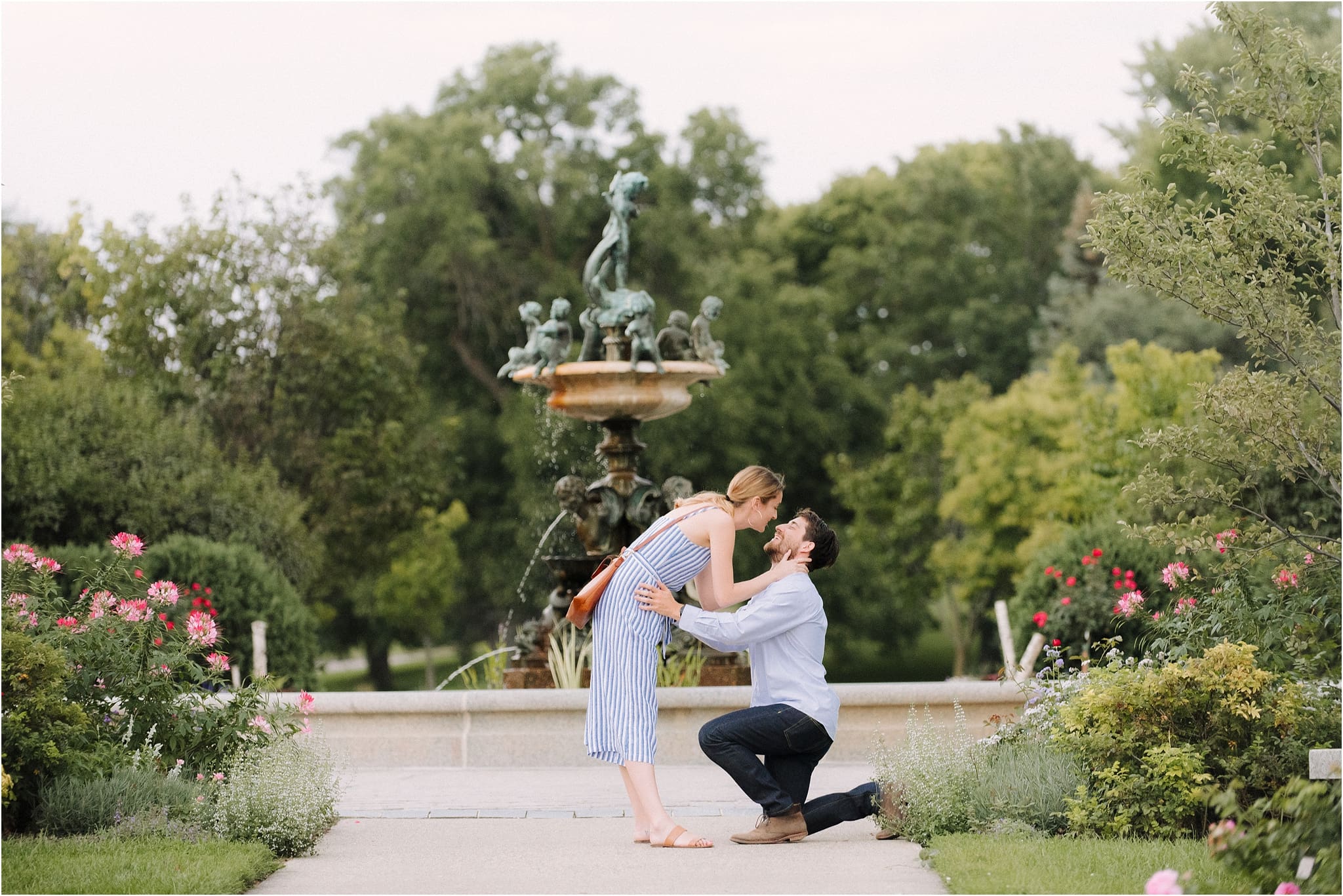 newly engaged couple kisses by fountain capture by Minneapolis Proposal Photographer