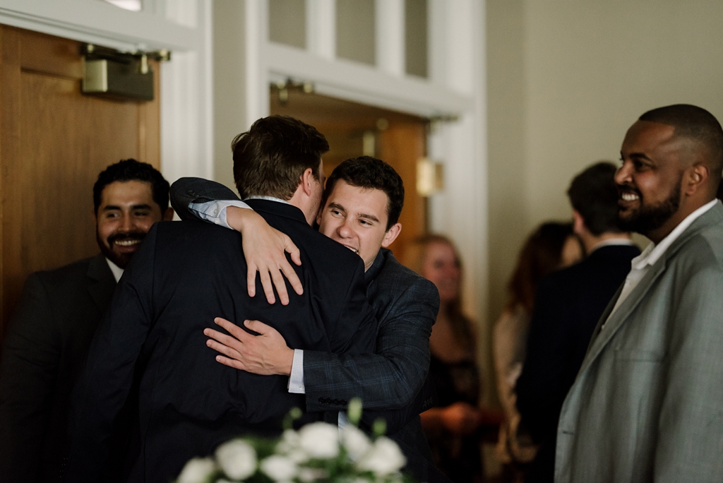 men embrace before wedding