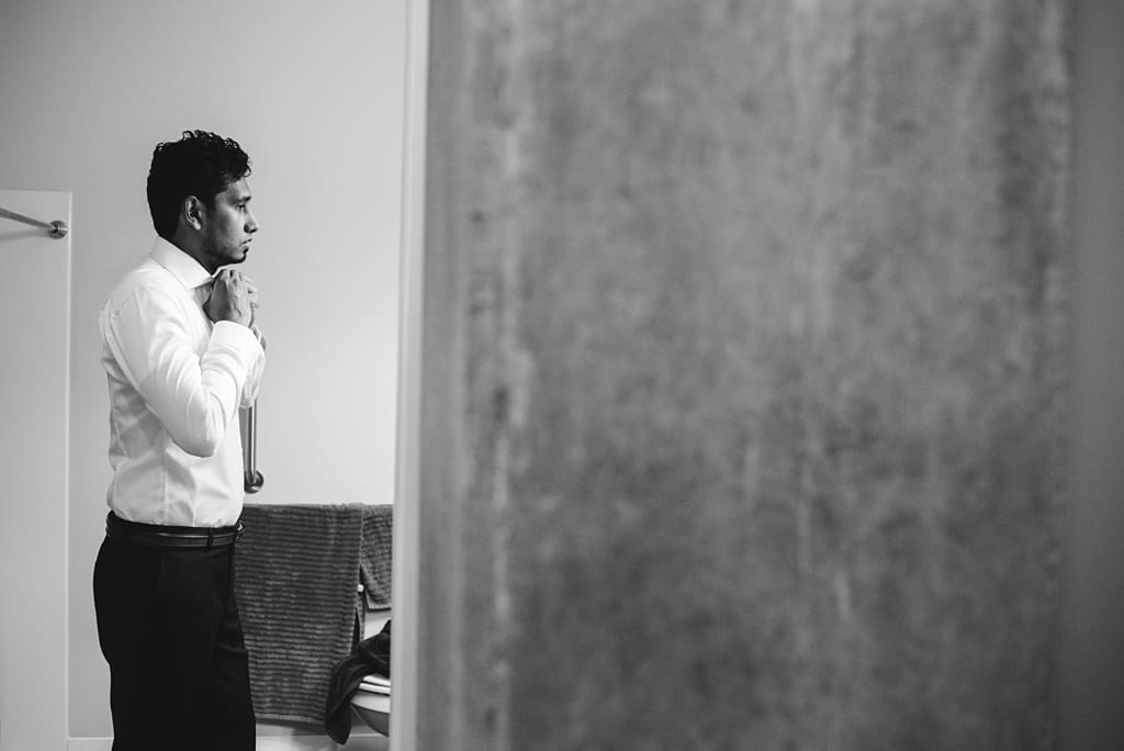 profile of groom straightening tie