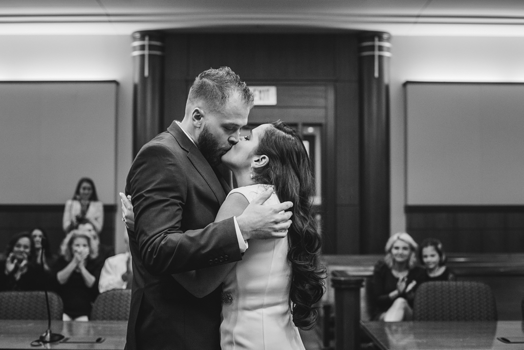 bride and groom kiss during city hall ceremony