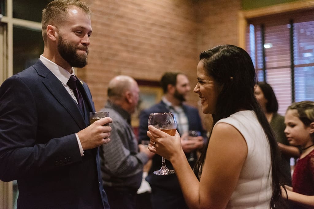 bride and groom drink wine and laugh