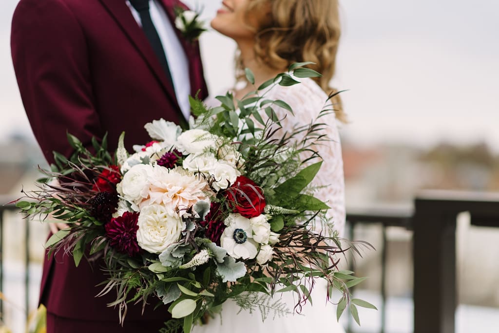 bridal bouquet with newlyweds in background