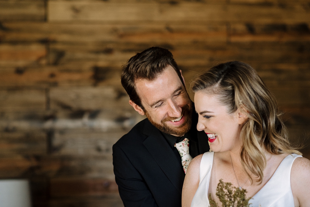 newlyweds laugh during couple portraits minnesota wedding