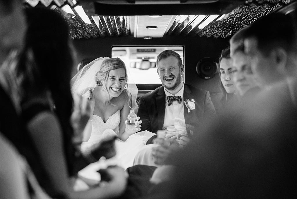 bride and groom with wedding party in bus