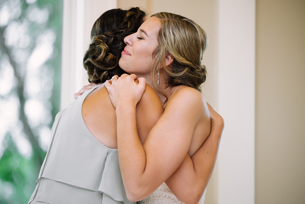 bride hugs bridesmaid at wedding reception