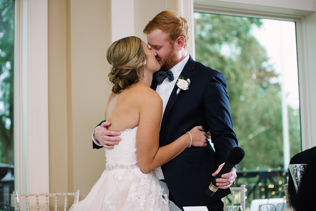 bride and groom kiss during reception speeches