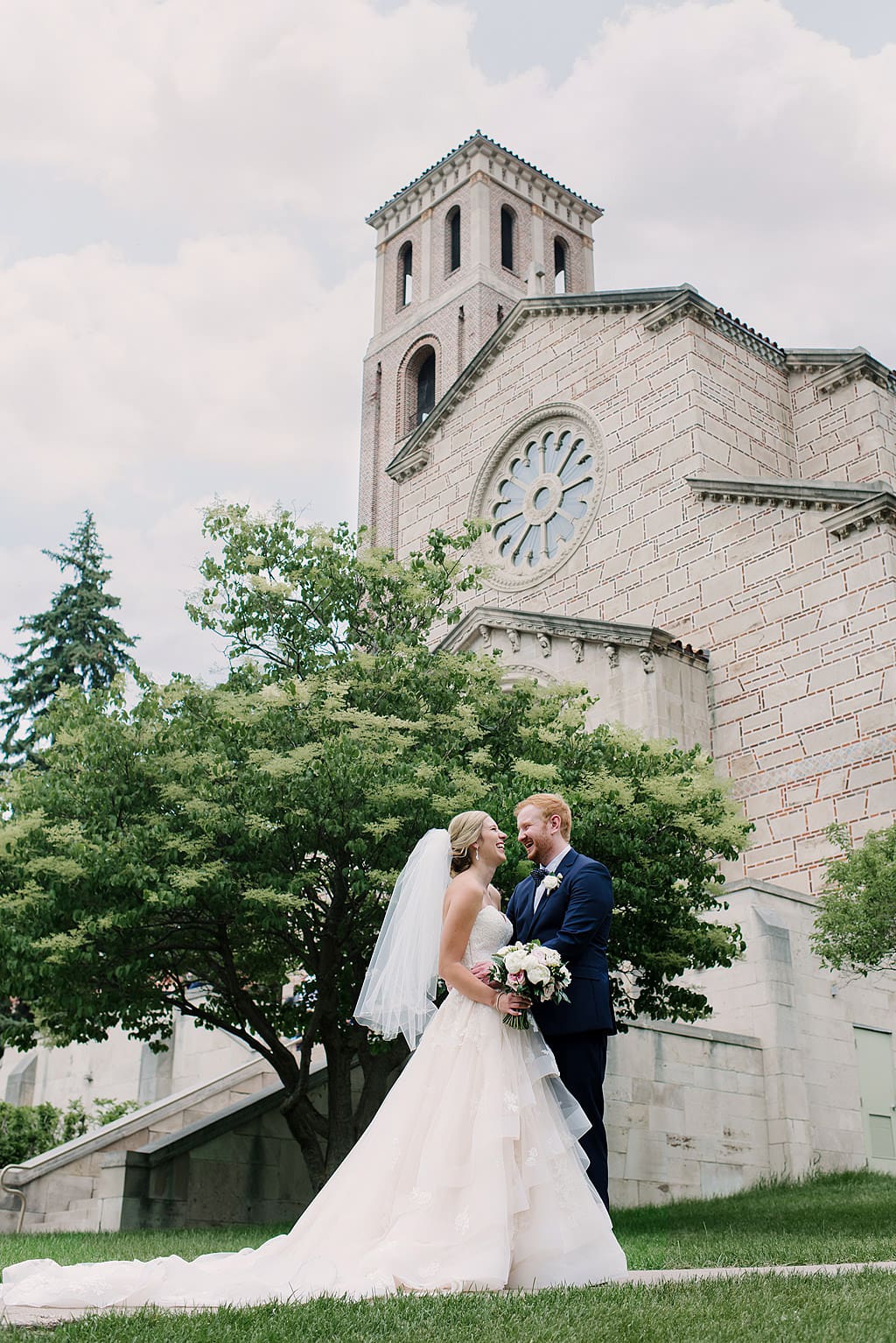 bride and groom outside chapel laughing together