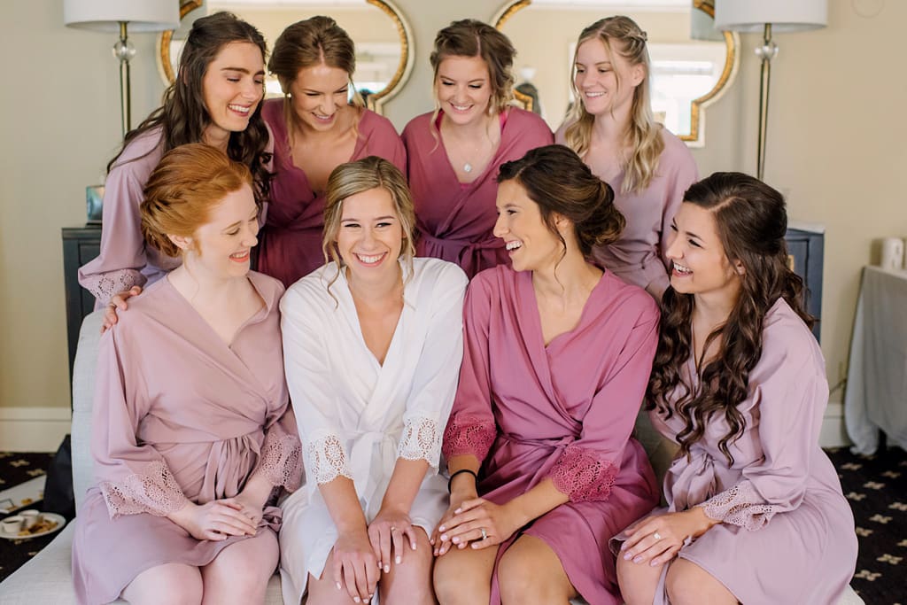 bride with bridesmaids in robes getting ready