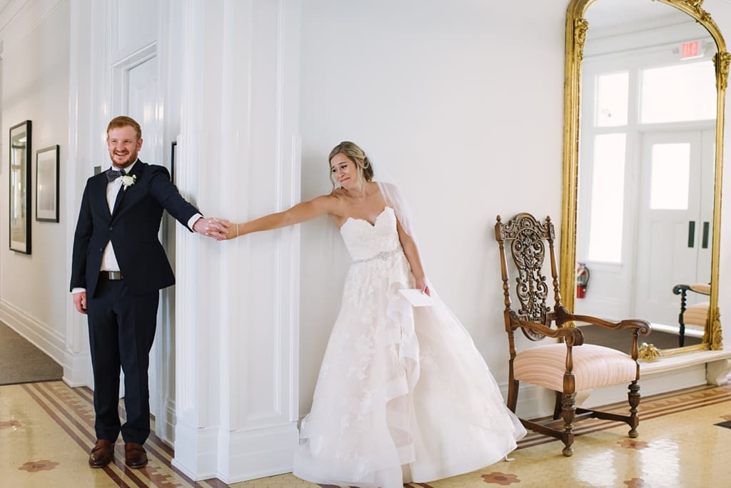 bride and groom holding hands around corner for their Minneapolis wedding