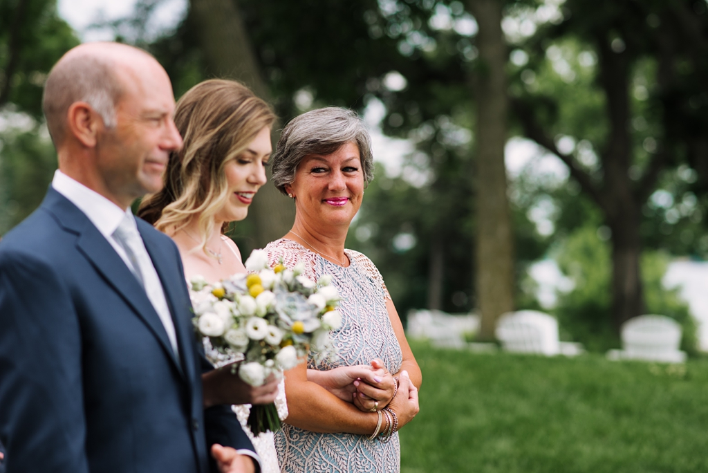 mother smiling at bride during backyard wedding