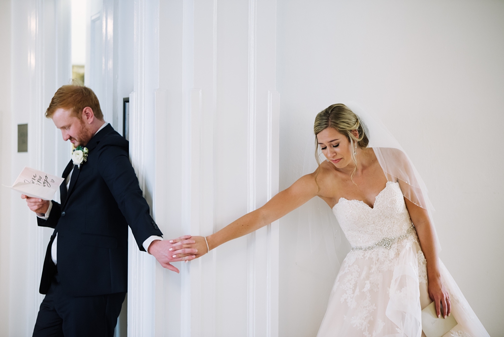 emotional bride and groom holding hands around corner