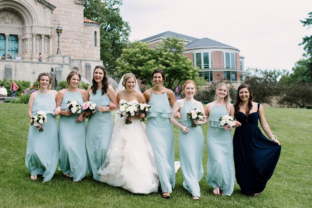 bridal party arm in arm walking toward camera