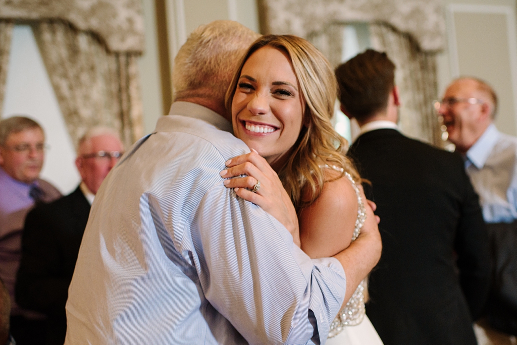 bride smiles and embraces guest during reception