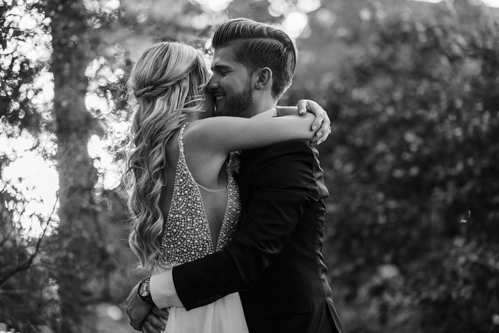 bride and groom hug outside after minnesota wedding