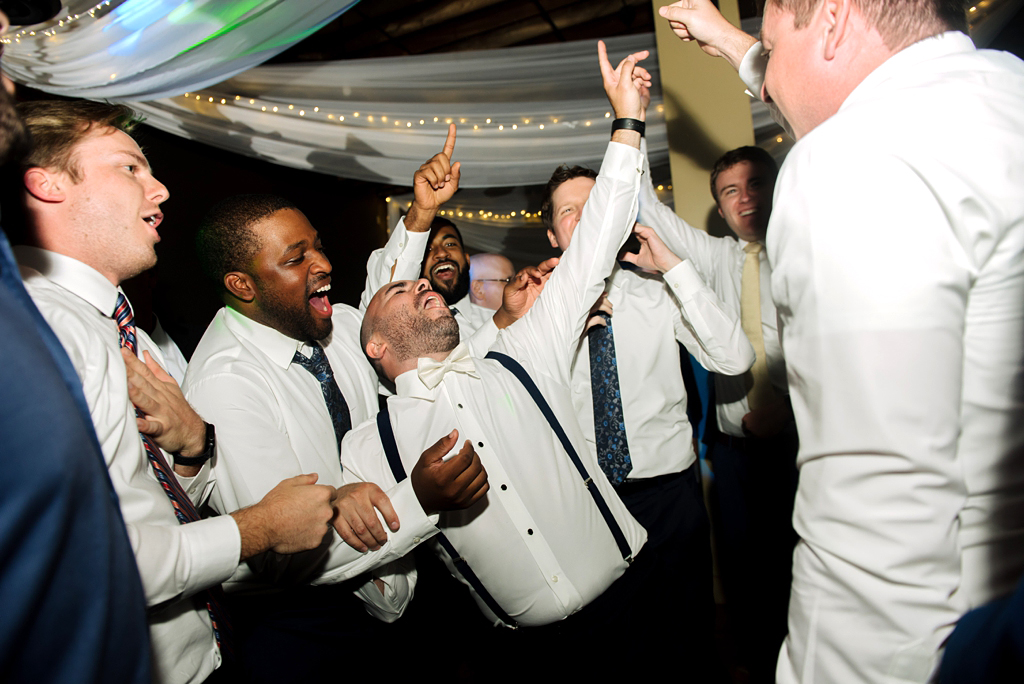 groom dancing with groomsmen at reception
