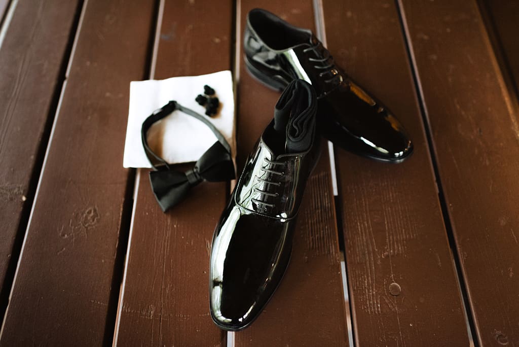 groom getting ready details shiny black shoes