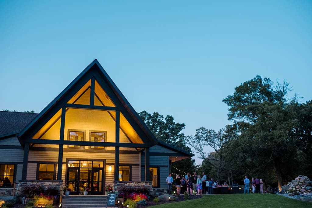 exterior of hidden green events venue at night with wedding guests