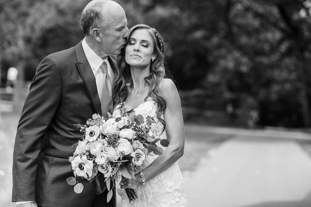 father of the bride kisses bride's temple