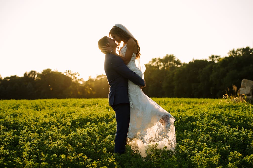 groom lifts bride off her feet for a kiss