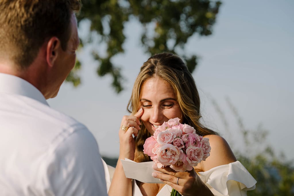 tearful bride reads vows during lakeside elopement