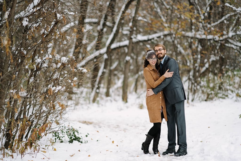 newlyweds embracing in snowy park