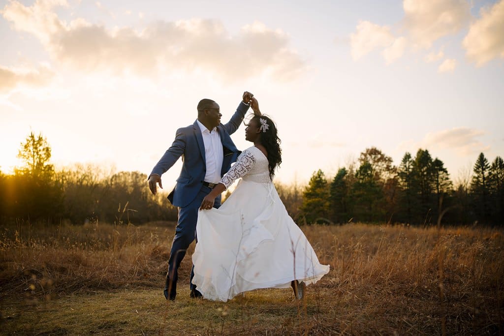 couple dancing in golden field at sunset