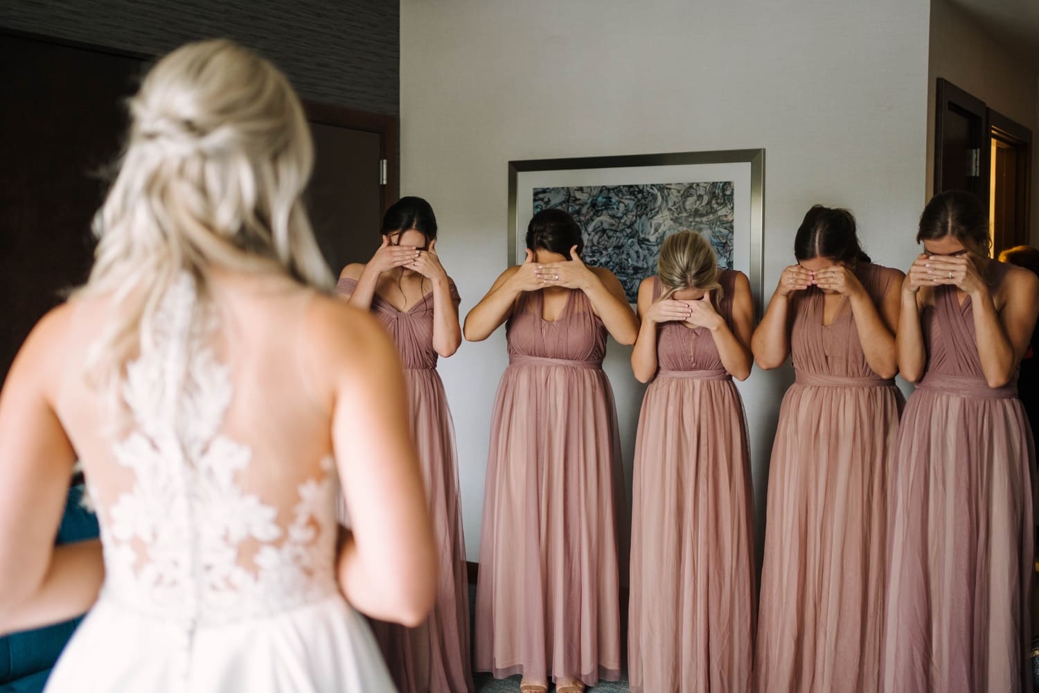 bridesmaids preparing for first look at bride in dress
