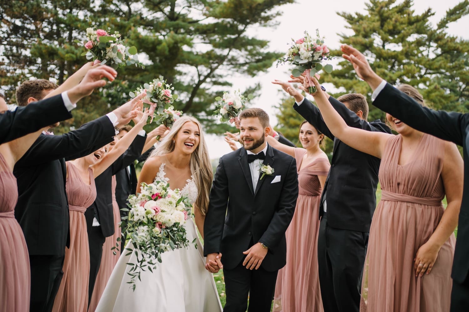 wedding party saluting bride and groom outside