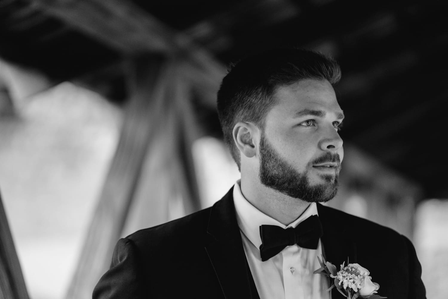 groom portrait on covered walking bridge