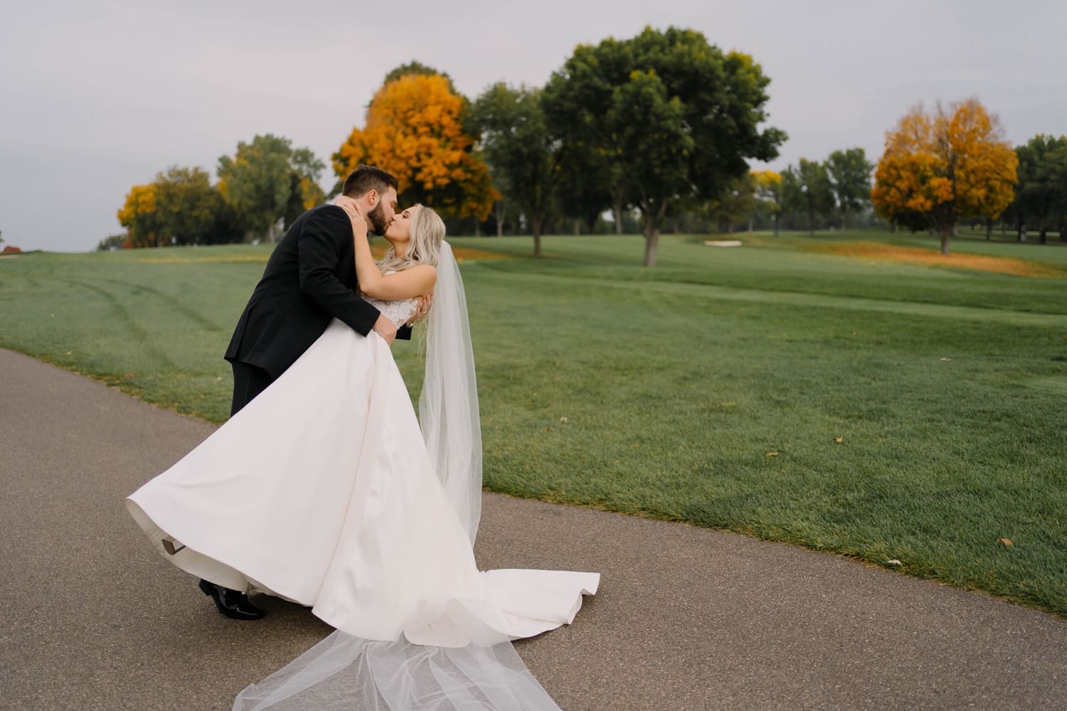 newlyweds kiss on golf course after ceremony