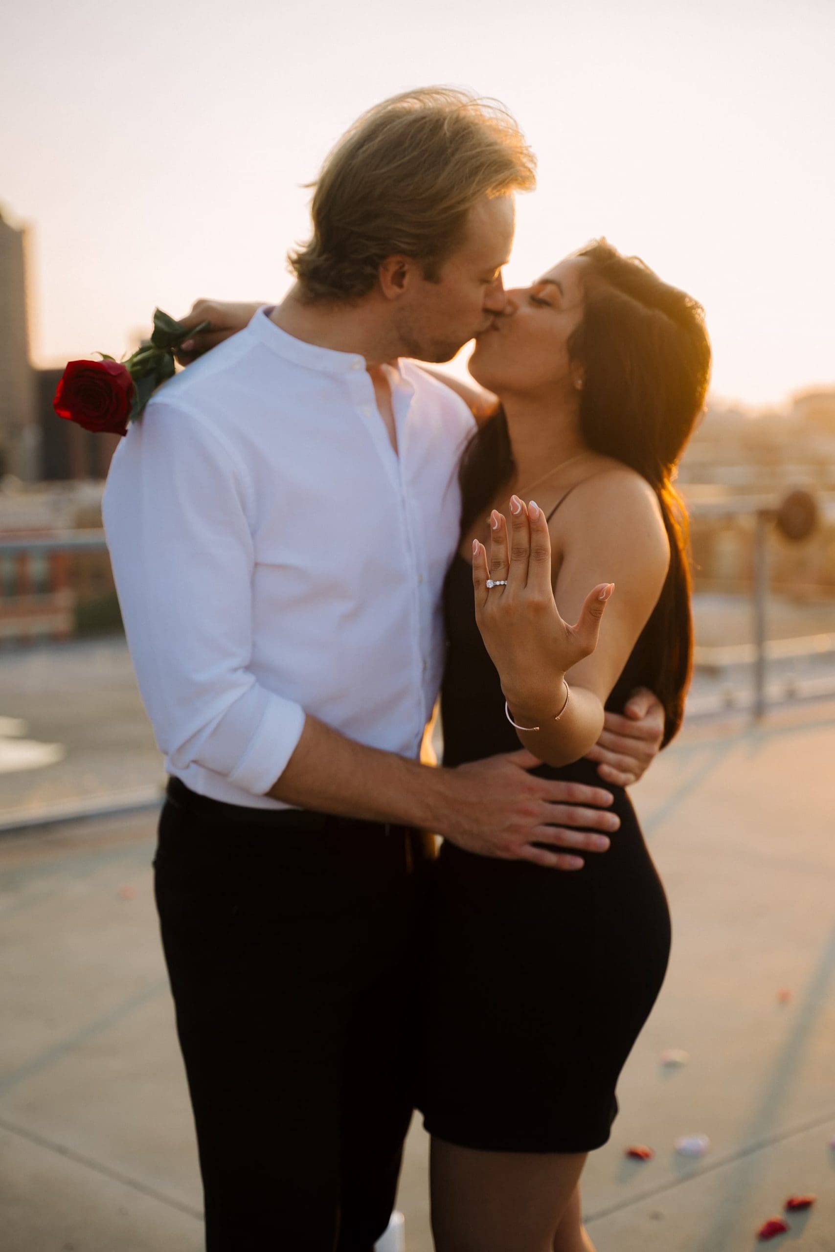 A'bulae rooftop proposal couple showing ring and kissing