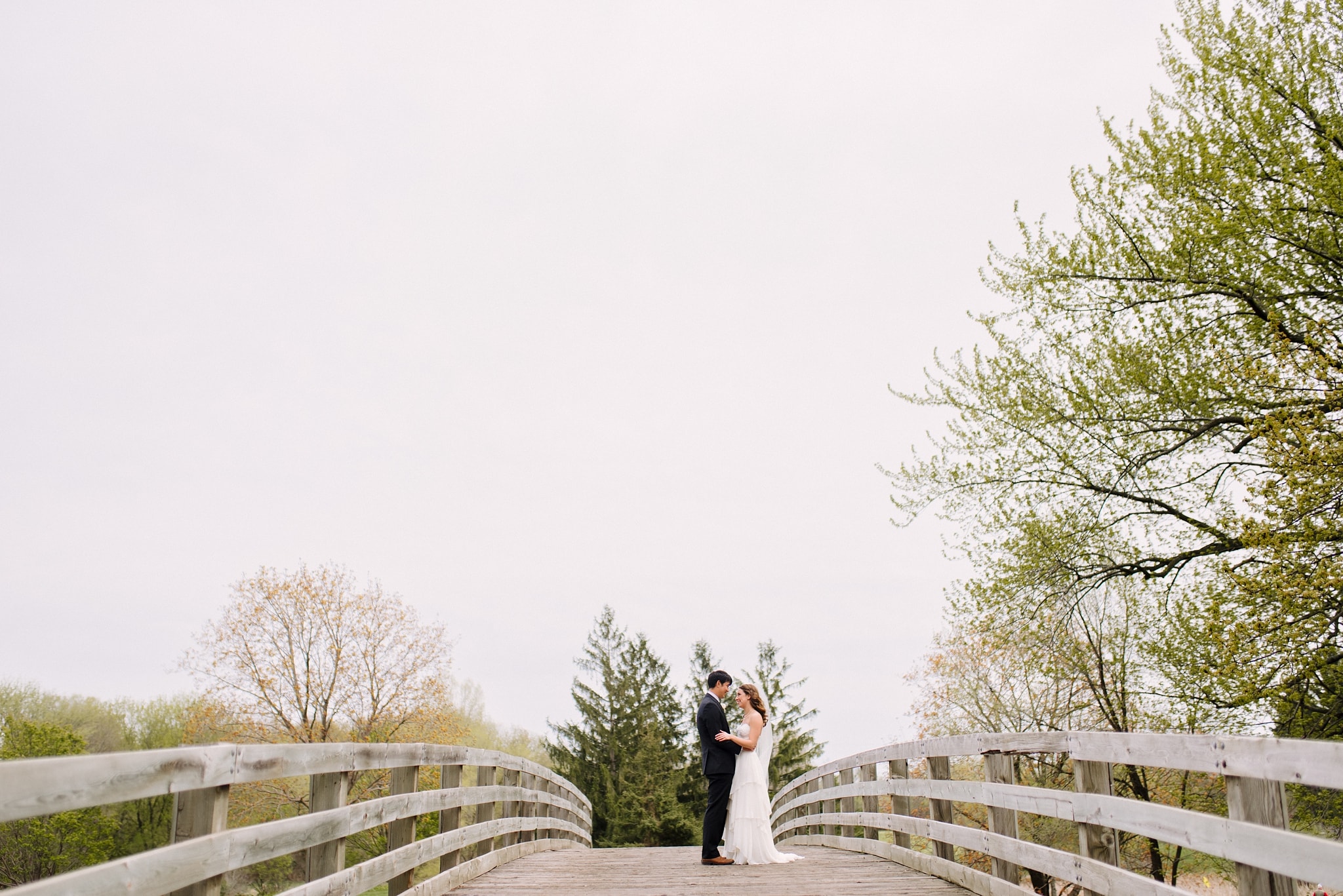 Bride and groom posing on bridge for their Minneapolis wedding photos