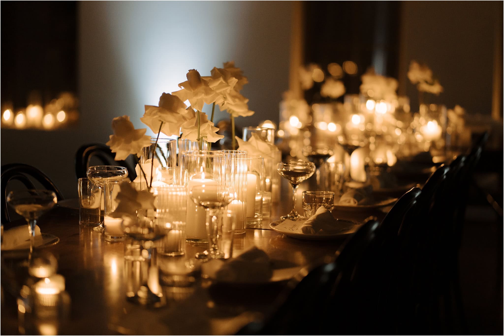 Candlelit wedding reception details in long table